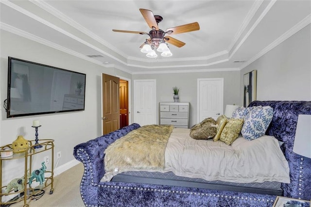 carpeted bedroom featuring a tray ceiling, ceiling fan, and ornamental molding