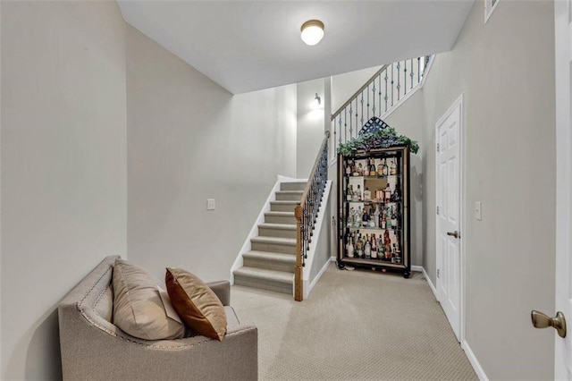 staircase featuring light colored carpet