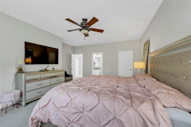 bedroom featuring ceiling fan, ensuite bathroom, and light colored carpet