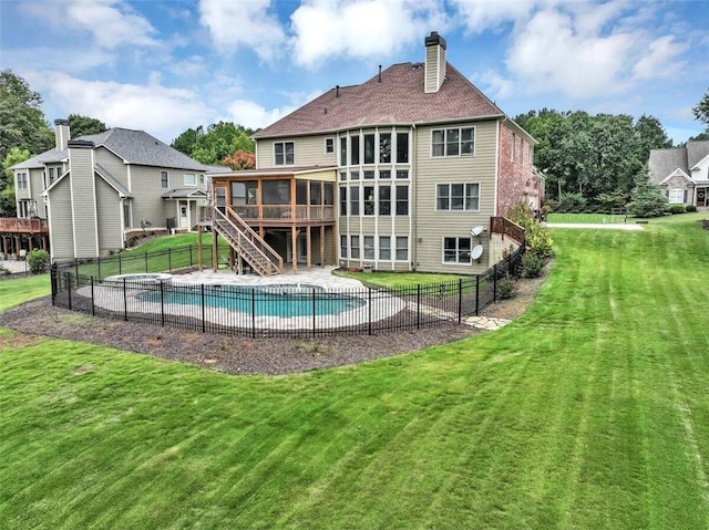 back of property with a yard, a sunroom, and a pool side deck