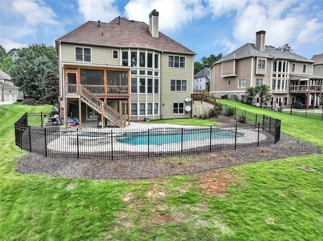 view of swimming pool featuring a sunroom and a lawn