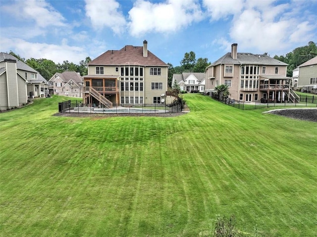 back of property featuring a yard and a swimming pool side deck