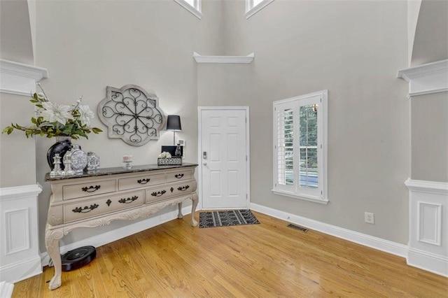 foyer entrance featuring light hardwood / wood-style floors and a high ceiling