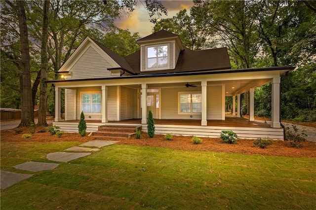 farmhouse featuring covered porch and a yard