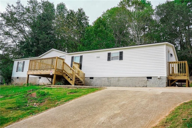 rear view of property featuring a yard and a deck