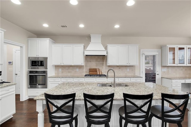 kitchen featuring white cabinetry, stainless steel appliances, sink, and custom exhaust hood