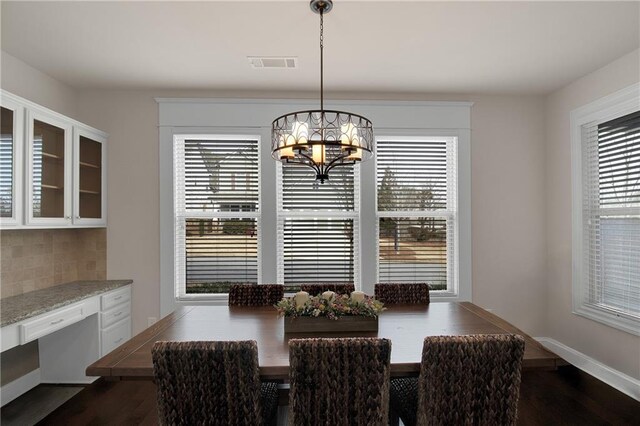 dining room with dark hardwood / wood-style flooring and a chandelier