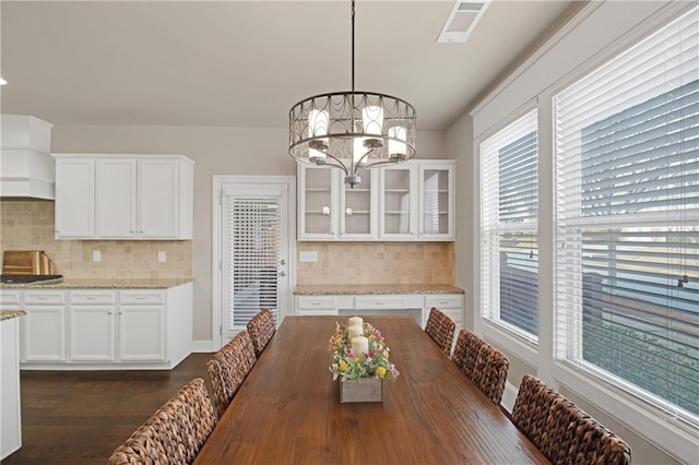 dining room with dark hardwood / wood-style flooring and an inviting chandelier