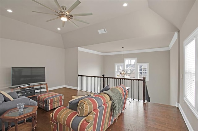 living room with vaulted ceiling, dark hardwood / wood-style floors, ceiling fan with notable chandelier, and crown molding