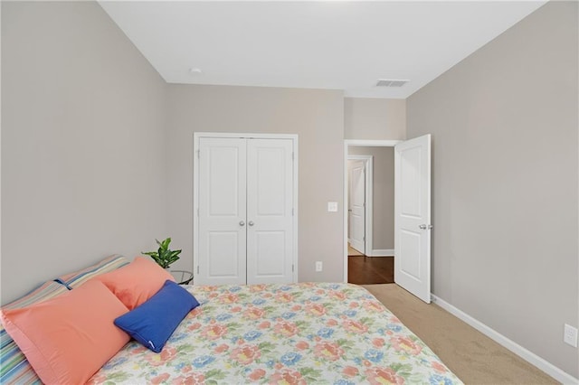 bedroom featuring light carpet and a closet