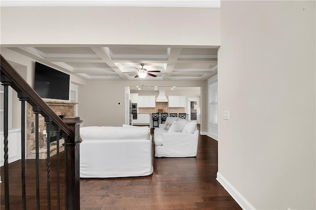 living room with coffered ceiling, ceiling fan, dark hardwood / wood-style flooring, and beamed ceiling