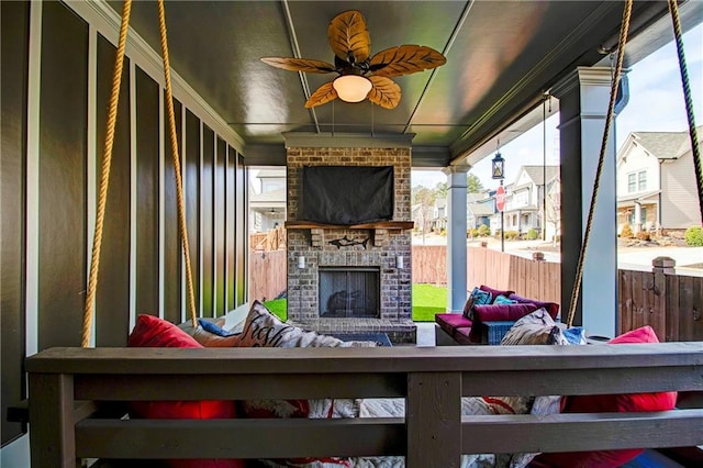 view of patio featuring ceiling fan and an outdoor living space with a fireplace