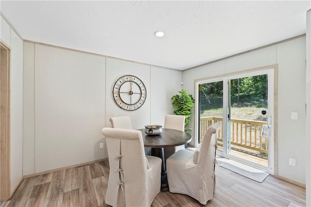 dining room featuring a textured ceiling and light wood-type flooring