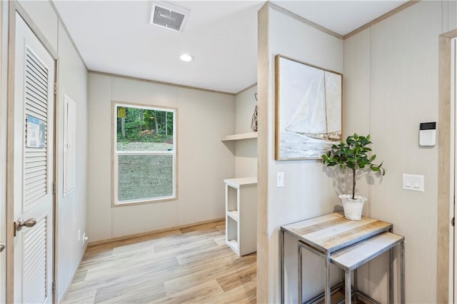 interior space featuring crown molding and light hardwood / wood-style floors