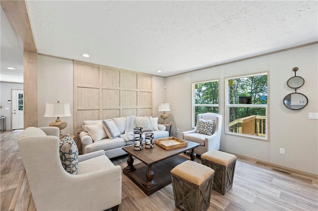 living room featuring a textured ceiling and light hardwood / wood-style flooring