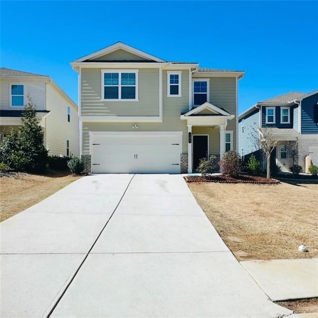 view of front of property featuring concrete driveway and an attached garage