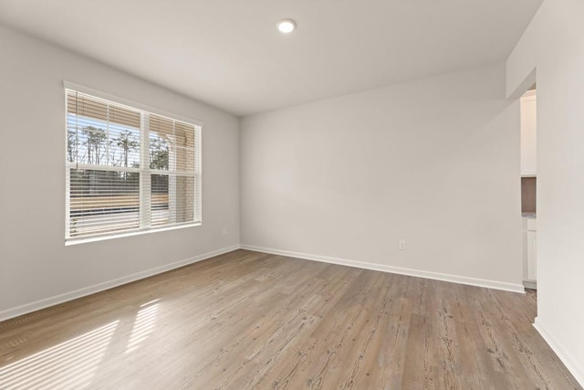 unfurnished room with light wood finished floors and baseboards