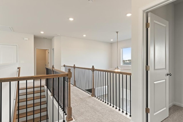 hallway featuring carpet, baseboards, an upstairs landing, and recessed lighting