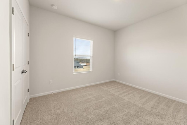 unfurnished bedroom featuring light carpet and baseboards