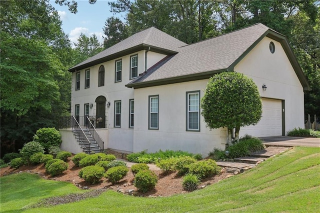 2819 Saddlebrook Way NW, Marietta, GA 30064 - colonial-style house featuring roof with shingles, stucco siding, a garage, a front yard, and driveway