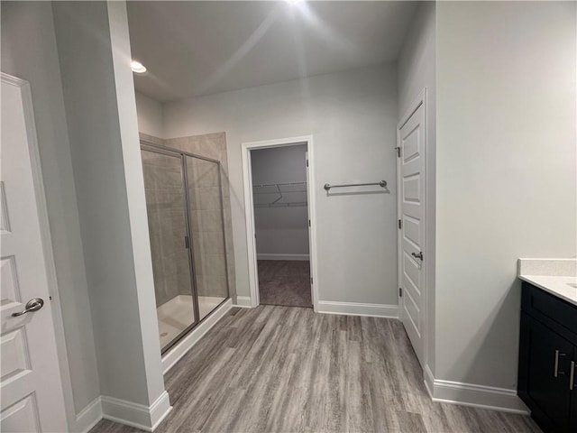 bathroom with vanity, a shower with shower door, and hardwood / wood-style flooring