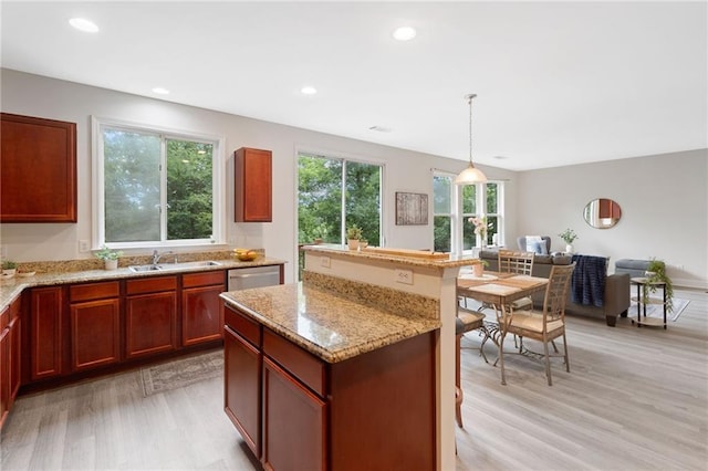 6018 Oakdale Rd SE, Mableton, GA 30126 - kitchen featuring light wood finished floors, dishwasher, a kitchen island, light stone counters, and hanging light fixtures