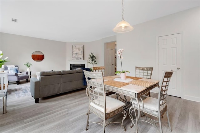 6018 Oakdale Rd SE, Mableton, GA 30126 - dining room featuring light wood-type flooring and a glass covered fireplace