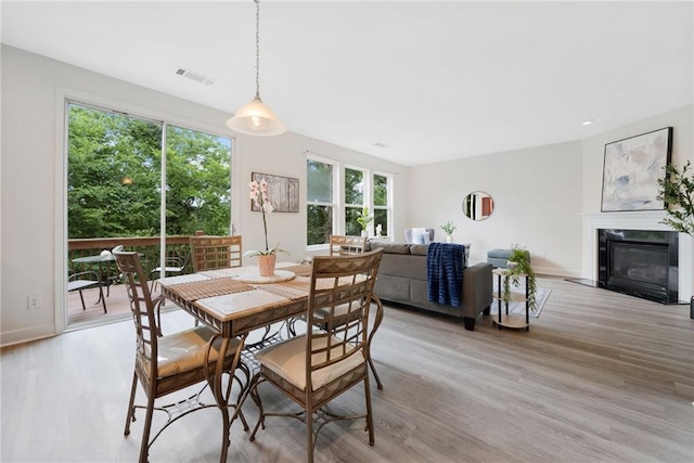 6018 Oakdale Rd SE, Mableton, GA 30126 - dining area with light wood-type flooring and a fireplace with flush hearth