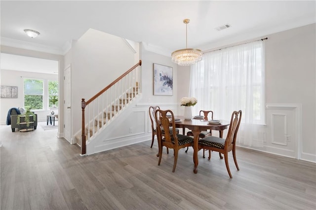6018 Oakdale Rd SE, Mableton, GA 30126 - dining space with stairs, a chandelier, wood finished floors, crown molding, and a decorative wall