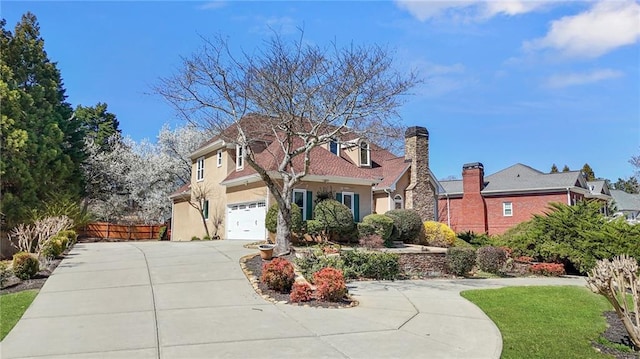 view of front of house featuring stucco siding, concrete driveway, an attached garage, and fence