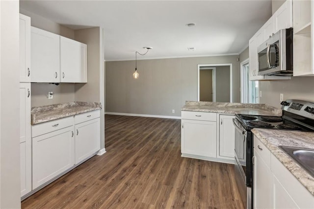 interior details with a fireplace, wood finished floors, baseboards, freestanding refrigerator, and ornamental molding