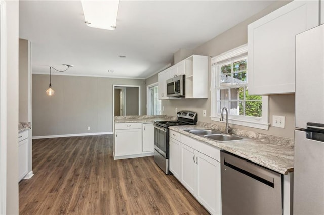 kitchen featuring crown molding, dark wood-style flooring, stainless steel appliances, white cabinetry, and a peninsula