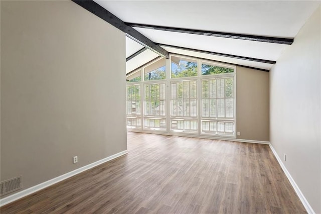 unfurnished bedroom featuring baseboards, connected bathroom, wood finished floors, and visible vents