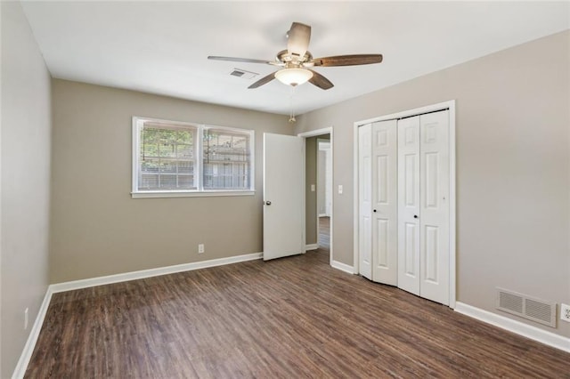 spare room featuring baseboards, visible vents, dark wood-style floors, and vaulted ceiling with beams