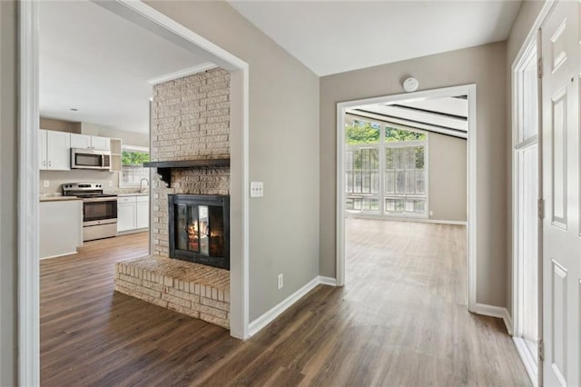 unfurnished living room with light wood-style floors, a ceiling fan, attic access, and built in shelves