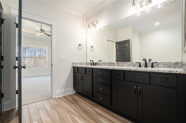 bathroom featuring crown molding, wood-type flooring, vanity, and ceiling fan