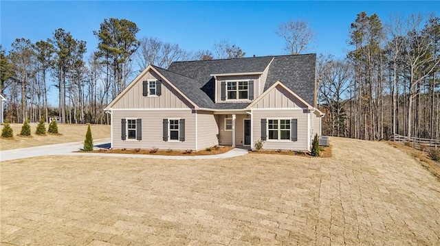 craftsman inspired home with central AC unit and a front lawn