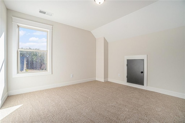 additional living space with vaulted ceiling and carpet flooring