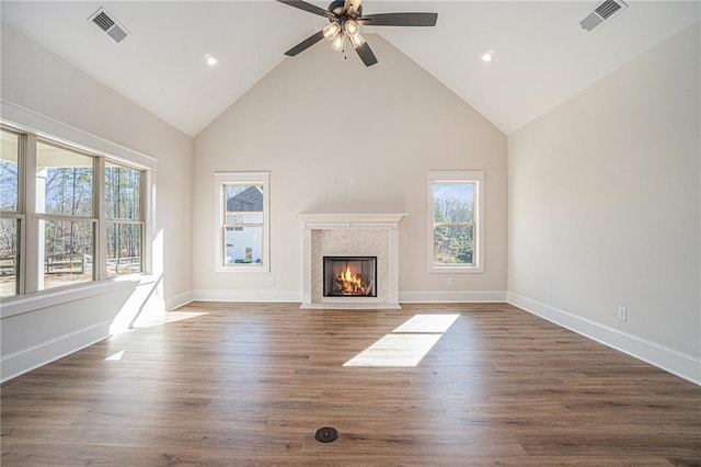 unfurnished living room with a premium fireplace, dark hardwood / wood-style floors, ceiling fan, and high vaulted ceiling