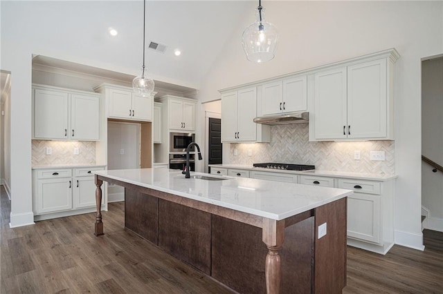 kitchen with built in microwave, sink, pendant lighting, and white cabinets