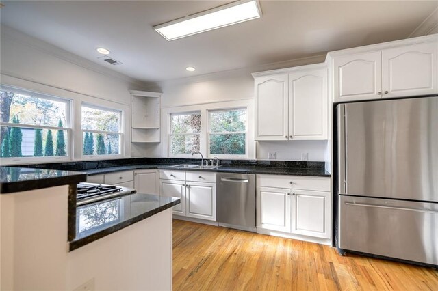 kitchen featuring plenty of natural light, white cabinets, stainless steel appliances, and light wood-type flooring