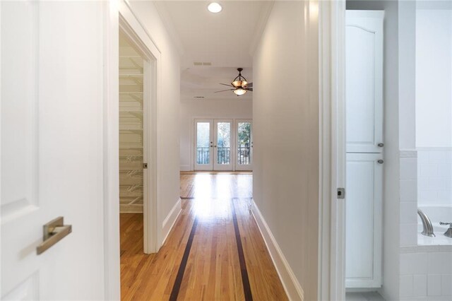 hall with french doors and light hardwood / wood-style flooring