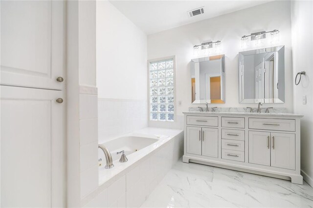 bathroom featuring vanity and a relaxing tiled tub