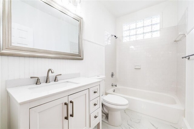 full bathroom with toilet, vanity, and tiled shower / bath