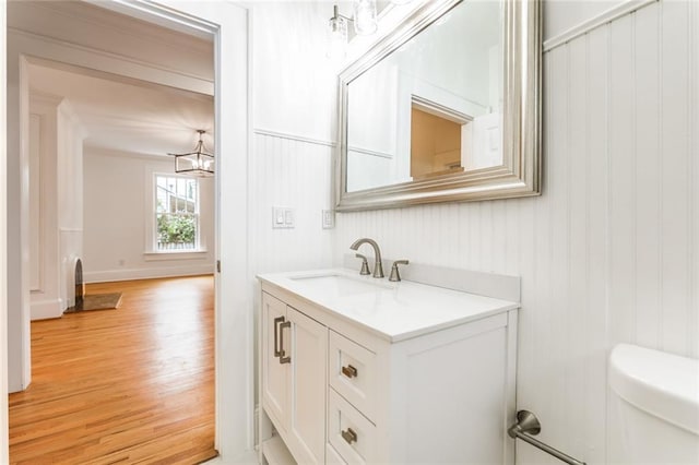 bathroom featuring wood-type flooring, vanity, and toilet