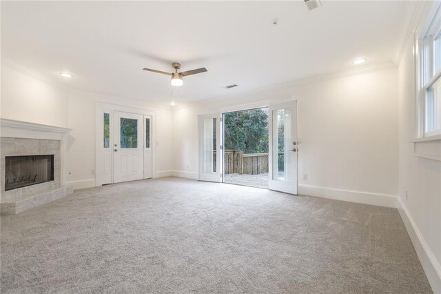 unfurnished living room with carpet, a wealth of natural light, and ceiling fan