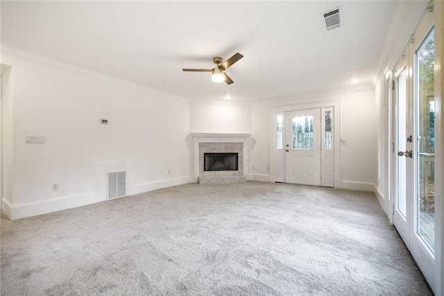 unfurnished living room with light carpet, ceiling fan, ornamental molding, and a premium fireplace