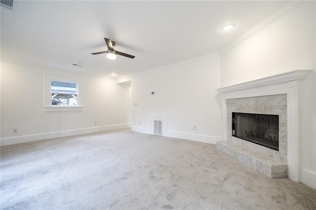 unfurnished living room with ceiling fan, ornamental molding, light carpet, and a tile fireplace