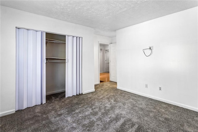 unfurnished bedroom with a closet, baseboards, carpet, and a textured ceiling