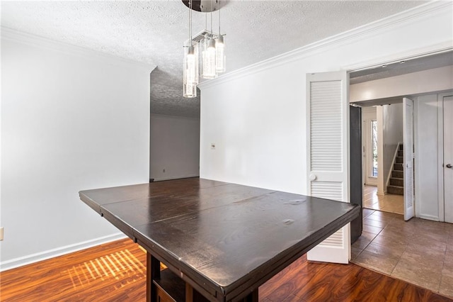 unfurnished dining area with a textured ceiling, wood finished floors, an inviting chandelier, crown molding, and stairs